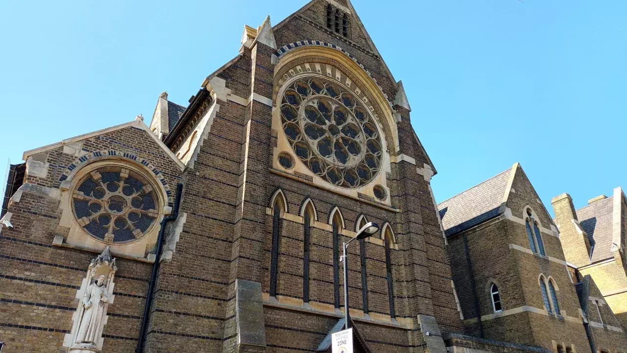 The rose window and brick façade of Our Lady of Sorrows Priory in Peckham